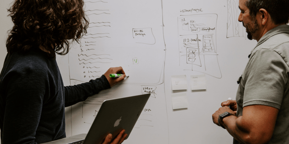Two people discussing in the whiteboard