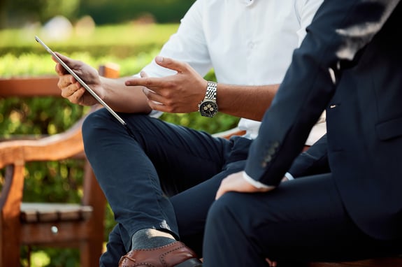 Two people discussing over a tablet